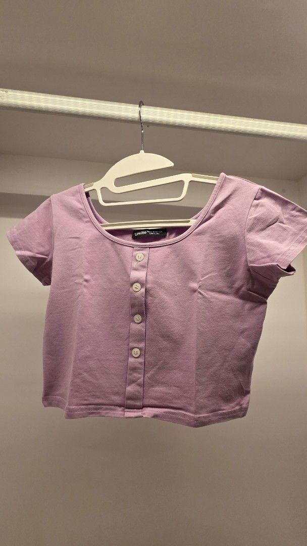Lovito Lilac Button Up Cropped Top (Category: Blouses) located in Mandaluyong City. Submitted by loijiminigo (Listing ID 1463457926, Image 1). Description: - Lovito lilac cropped top - Short sleeves - Button-up front - Soft and comfortable fabric - Versatile for casual or dressed-up outfits - Easy to pair with jeans or skirts.