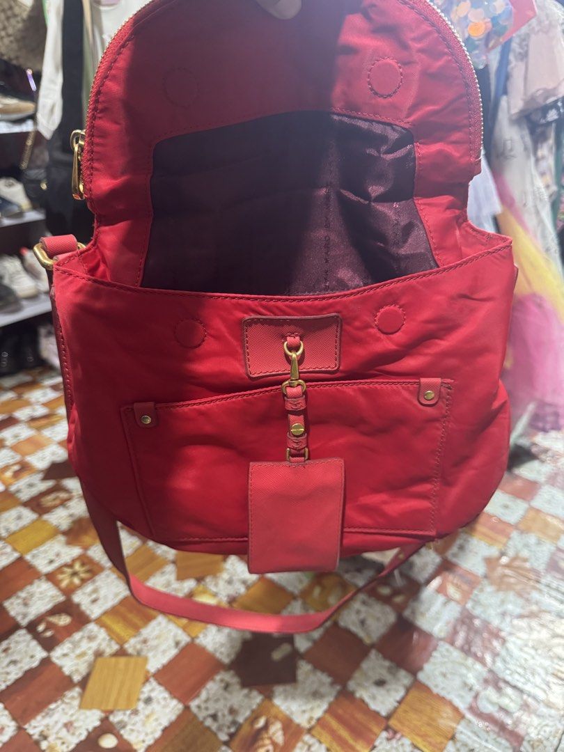 Marc by Marc Jacobs Nylon Crossbody Bag (Category: Luxury Bags & Wallets) located in Manila. Submitted by wildbear.e10374 (Listing ID 1463389743, Image 3). Description: - Brand: Marc by Marc Jacobs - Color: Red - Material: Nylon - Style: Crossbody bag - Closure: Flap with magnetic snaps - Pockets: Front zip pocket, interior zip pocket - Strap: Adjustable - Extras: Small leather tag - Ideal for: Everyday use.