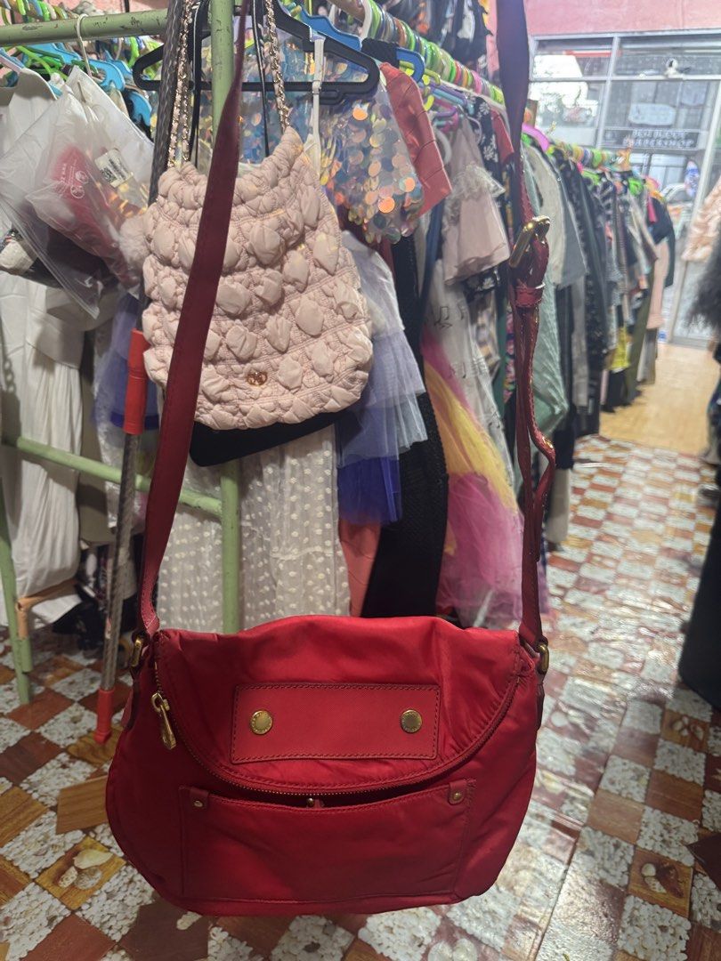 Marc by Marc Jacobs Nylon Crossbody Bag (Category: Luxury Bags & Wallets) located in Manila. Submitted by wildbear.e10374 (Listing ID 1463389743, Image 2). Description: - Brand: Marc by Marc Jacobs - Color: Red - Material: Nylon - Style: Crossbody bag - Closure: Flap with magnetic snaps - Pockets: Front zip pocket, interior zip pocket - Strap: Adjustable - Extras: Small leather tag - Ideal for: Everyday use.