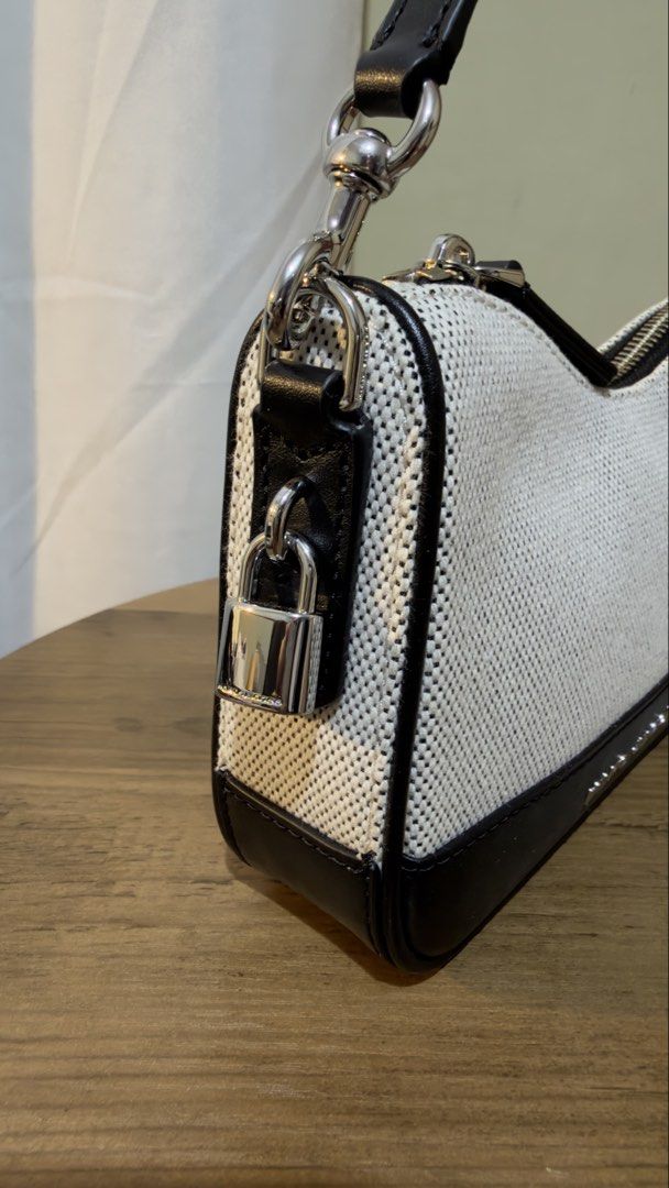 Marc Jacobs Canvas & Leather Shoulder Bag (Category: Luxury Bags & Wallets) located in Las Pinas. Submitted by tanmaine (Listing ID 1463332154, Image 3). Description: - Brand: Marc Jacobs - Style: Shoulder Bag - Color: Black and White Canvas with Black Leather Trim - Closure: Zipper - Features: Small padlock detail on the side - Condition: Comes with original tags and care cards - Ideal for: Everyday use.