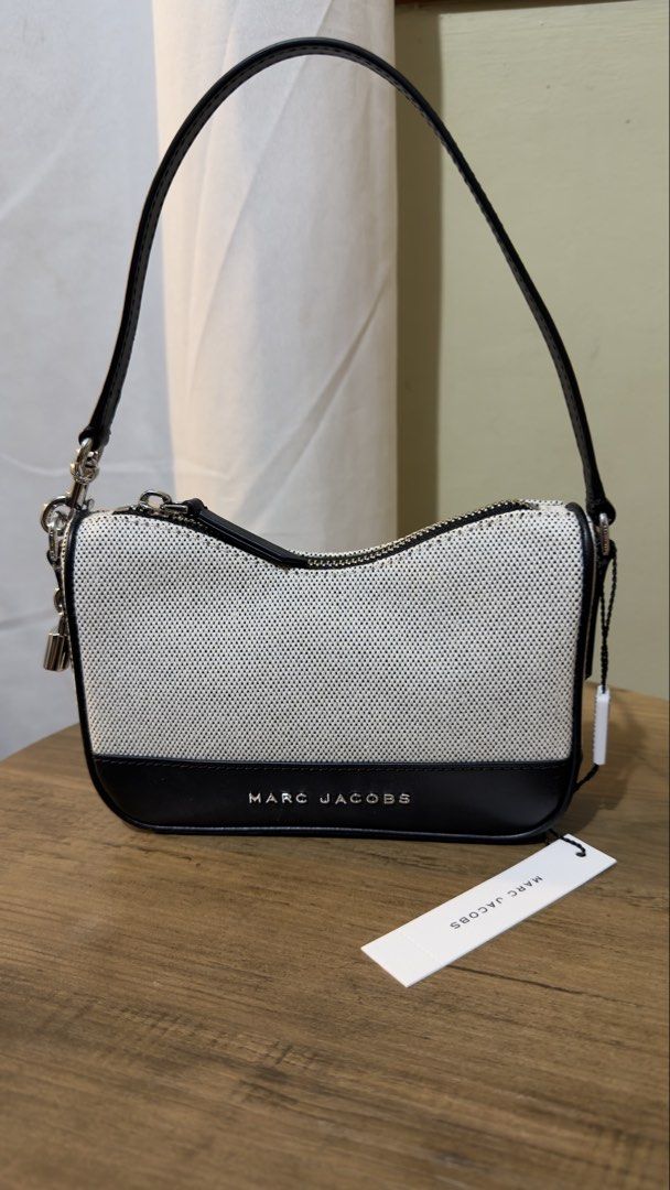 Marc Jacobs Canvas & Leather Shoulder Bag (Category: Luxury Bags & Wallets) located in Las Pinas. Submitted by tanmaine (Listing ID 1463332154, Image 2). Description: - Brand: Marc Jacobs - Style: Shoulder Bag - Color: Black and White Canvas with Black Leather Trim - Closure: Zipper - Features: Small padlock detail on the side - Condition: Comes with original tags and care cards - Ideal for: Everyday use.
