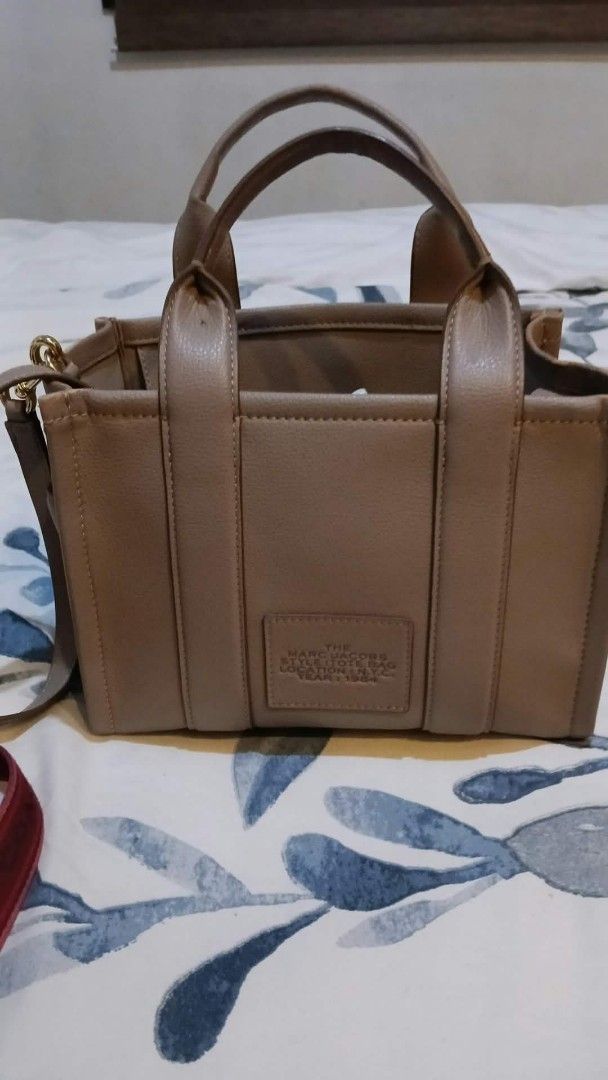 Marc Jacobs The Tote Bag (Category: Luxury Bags & Wallets) located in Quezon City. Submitted by elihur.tuazon (Listing ID 1463327807, Image 2). Description: - Authentic Marc Jacobs The Tote Bag - Chic beige color - Made from premium leather - Versatile: top handles and adjustable crossbody strap - Ample interior space for all your essentials - Ideal for everyday wear - Please review photos for detailed condition.