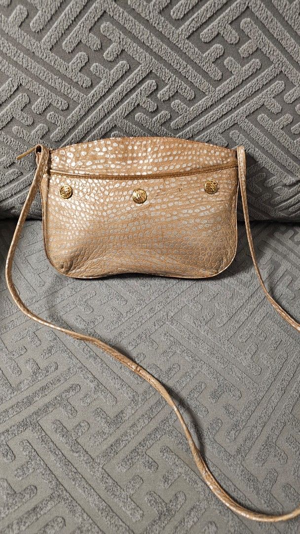 Mariotti Italy leather sling bag (Category: Cross-body Bags) located in Quezon City. Submitted by jollythrift (Listing ID 1463503314, Image 1). Description: - Small gold crossbody bag - Unique textured exterior with a distinct pattern - external side pocket - Zipper main closure and inside for your belongings - Ideal for carrying your daily essentials.
