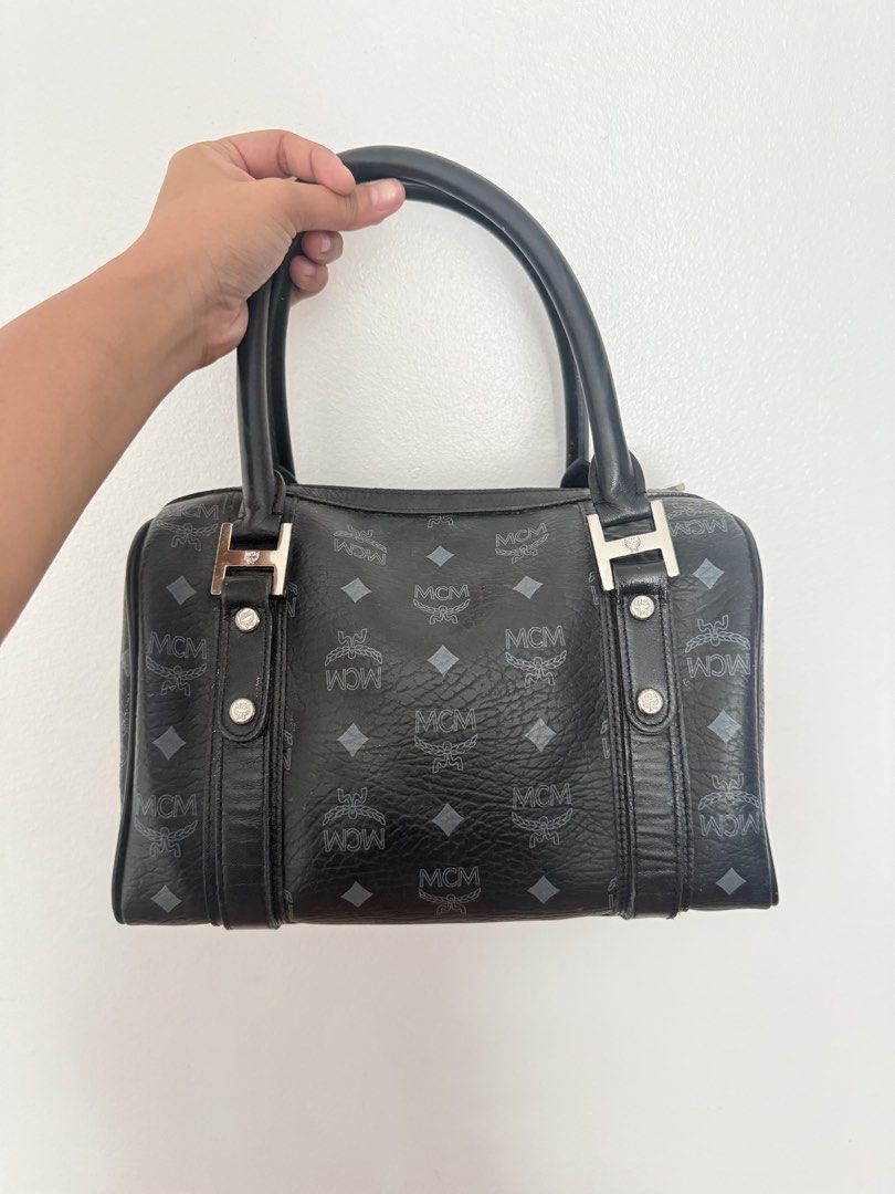 MCM Monogram Boston Bag Black Leather (Category: Luxury Bags & Wallets) located in Manila. Submitted by epicmoon_e05e67 (Listing ID 1463476041, Image 2). Description: - Classic MCM Boston bag - Black leather with signature MCM monogram print - Front pocket with snap closure - Top handles for carrying - Silver hardware details - Timeless and iconic piece Unli vc for legitimacy yes to lalamove / j&t condition: 8.5/10 will indicate via videocall if 