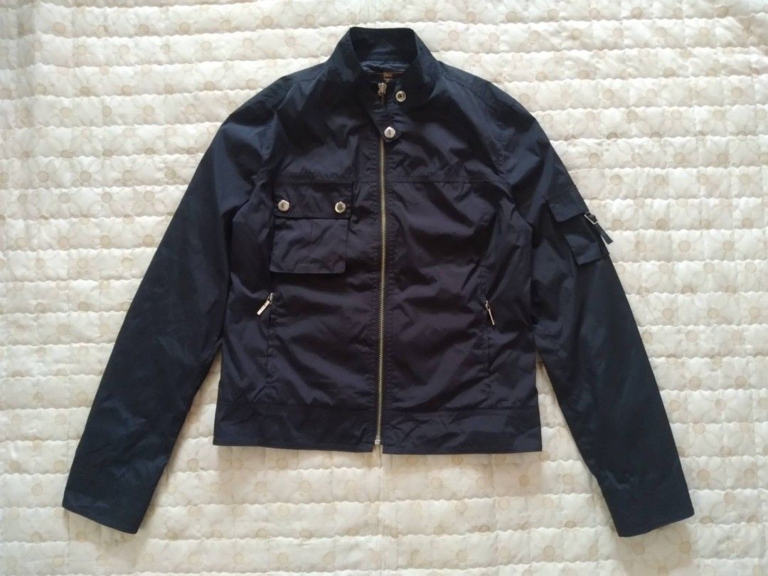 MCM Nylon Black Jacket Women (Category: Luxury Apparel) located in Zamboanga. Submitted by nurbya898048 (Listing ID 1463392310, Image 1). Description: Black nylon MCM jacket. Zip-up front with snap button pockets. Has a pocket on the left sleeve with a buckle closure. MCM logo details on the buttons and zipper pull. Great for casual wear. Tag size 90/medium Width 18 Length 21 Black color way Nylon/satin cloth In good condition Check all photos fo