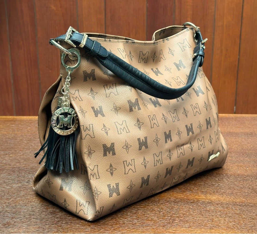 Metrocity shoulder bag (Category: Shoulder Bags) located in Bulacan. Submitted by thriftbagcollections (Listing ID 1463395936, Image 3). Description: Brown monogram Metrocity shoulder bag featuring a black leather handle and a dangling black tassel charm.Good condition with dents on edges only,Approx;H-10.5”W-16”D-5.5” handle 6”.