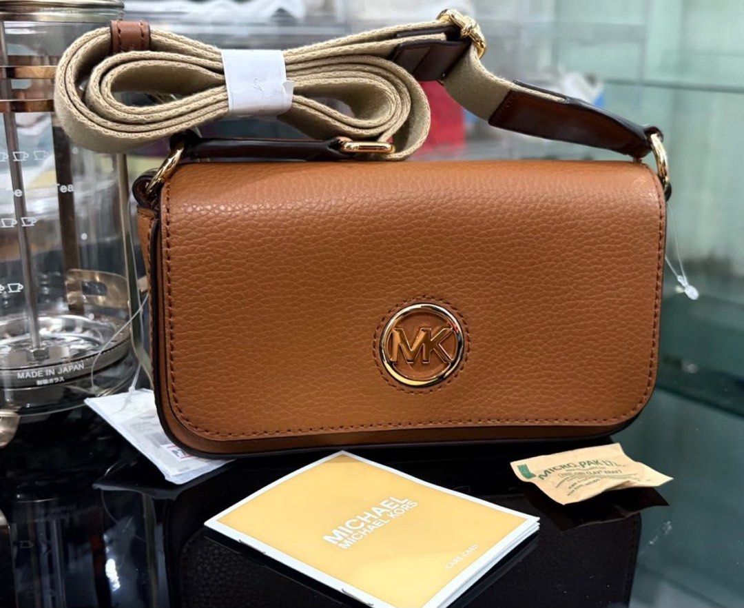 Michael Kors Brown Leather Crossbody Bag (Category: Cross-body Bags) located in Manila. Submitted by manyi04 (Listing ID 1463367301, Image 2). Description: - Brand: Michael Kors - Material: Brown pebbled leather - Hardware: Gold MK logo on front - Strap: Adjustable - Included: Care card - Ideal for: Everyday use.