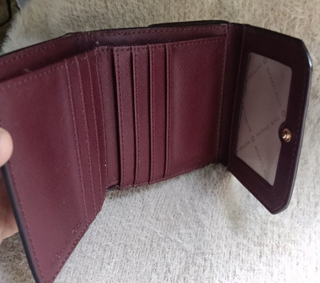 Michael Kors Burgundy Monogram Tri-Fold Wallet (Category: Wallets & Card holders) located in Antipolo. Submitted by vastgem_4c8da8 (Listing ID 1463352702, Image 3). Description: - Authentic Michael Kors tri-fold wallet in burgundy. - Features the iconic MK monogram pattern. - Multiple card slots for organization. - Includes a clear ID window. - Secure snap closure. - Please note: minor signs of wear inside, as shown in photos..