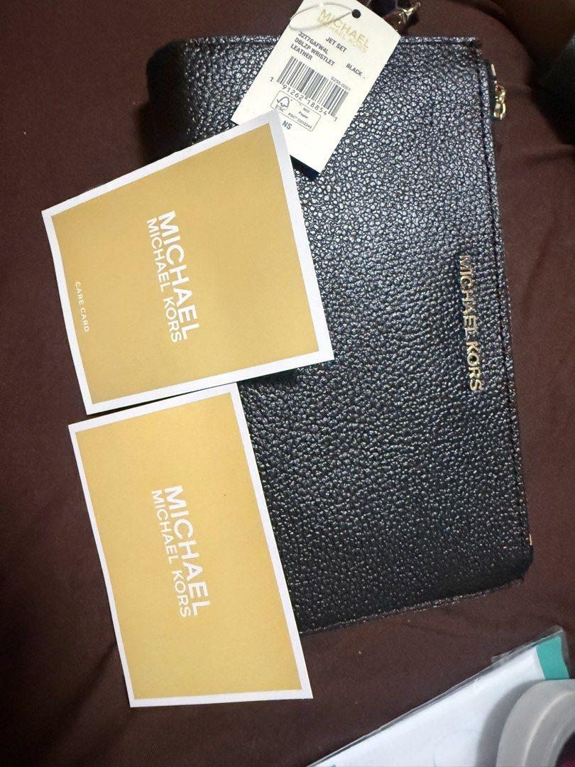 Michael Kors Leather Top Zip Wristlet Black (Category: Wallets & Card holders) located in Makati City. Submitted by jelqtee (Listing ID 1463328941, Image 1). Description: Michael Kors black pebbled leather wristlet with zip-around closure. Features card slots, ID window, and gold-tone hardware. Includes care cards. Bought from 🇨🇦.