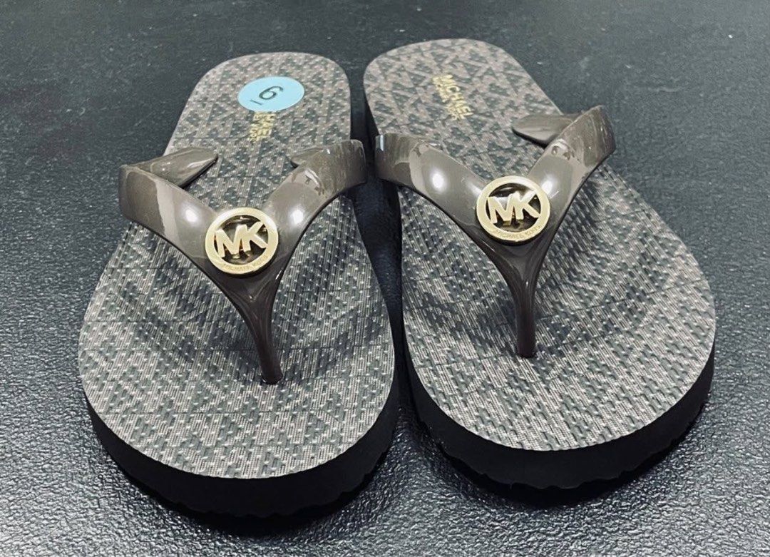 Michael Kors MK Logo Flip-Flops Size 6 (Category: Slippers and slides) located in Manila. Submitted by manyi04 (Listing ID 1463367178, Image 1). Description: - Michael Kors Flip-Flops - Size: 6 - Classic all-over MK logo pattern on footbed - Dark brown, translucent straps - Gold MK logo charm on straps - Ideal for beach or casual outings - Easy slip-on style.