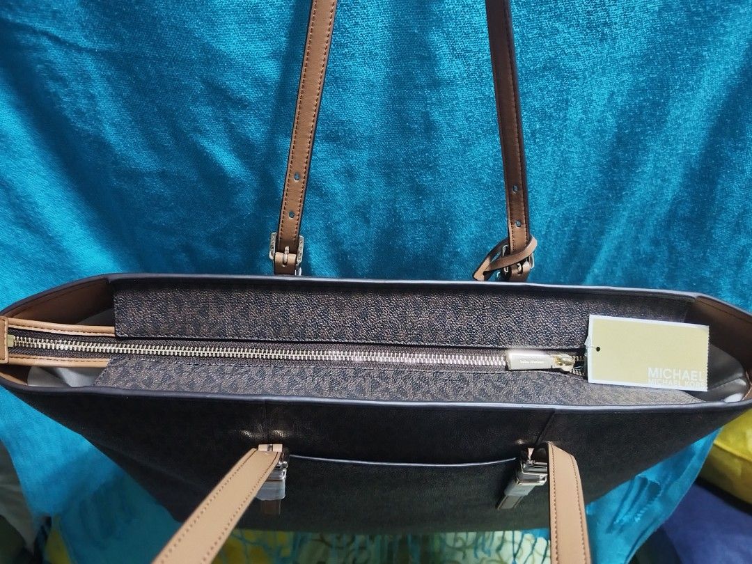 Michael Kors Monogram Tote Bag Brown (Category: Luxury Bags & Wallets) located in Caloocan City. Submitted by jpmshoppe (Listing ID 1463362770, Image 3). Description: - Authentic Michael Kors tote bag - Signature brown monogram print - Tan leather straps and trim - Secure zipper closure for main compartment - Interior zip pocket and slip pockets - Made in Indonesia - Comes with original tags.