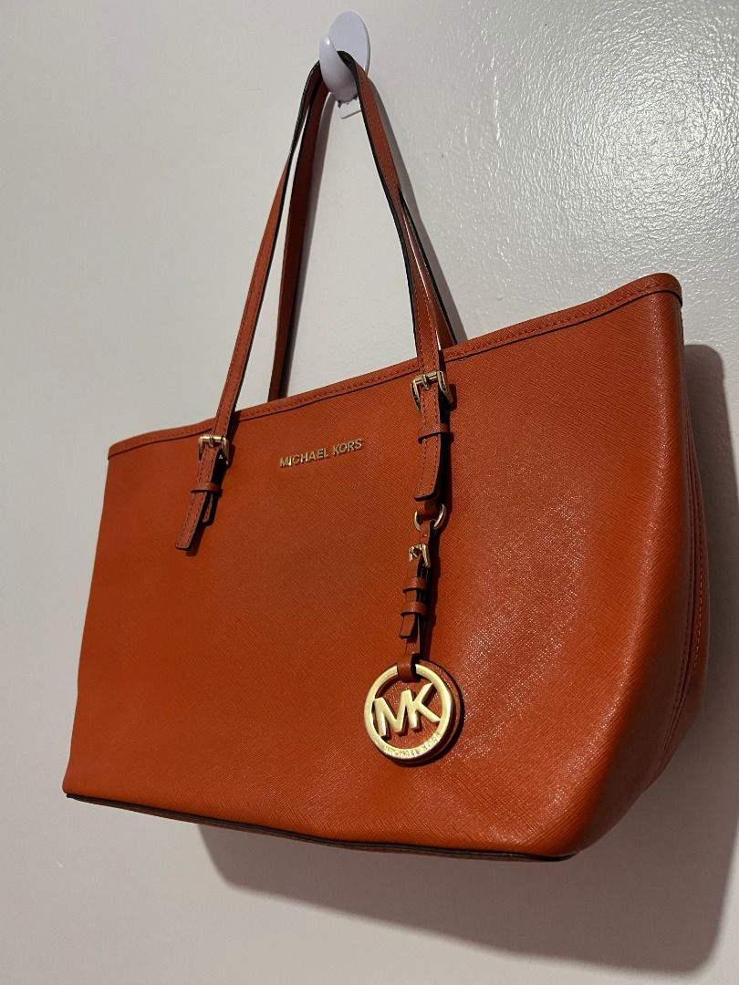 Michael Kors Orange Leather Tote Bag (Category: Luxury Bags & Wallets) located in Caloocan City. Submitted by jpnusapasabuyfindsdvo (Listing ID 1463515634, Image 3). Description: Michael Kors Jet Set Travel Medium Saffiano Leather Tote (Orange) - Authentic Orange Michael Kors tote bag - Genuine leather material - Elegant gold hardware details - Iconic MK charm hanging from the strap - Very spacious interior, ideal for everyday essentials - Meticu