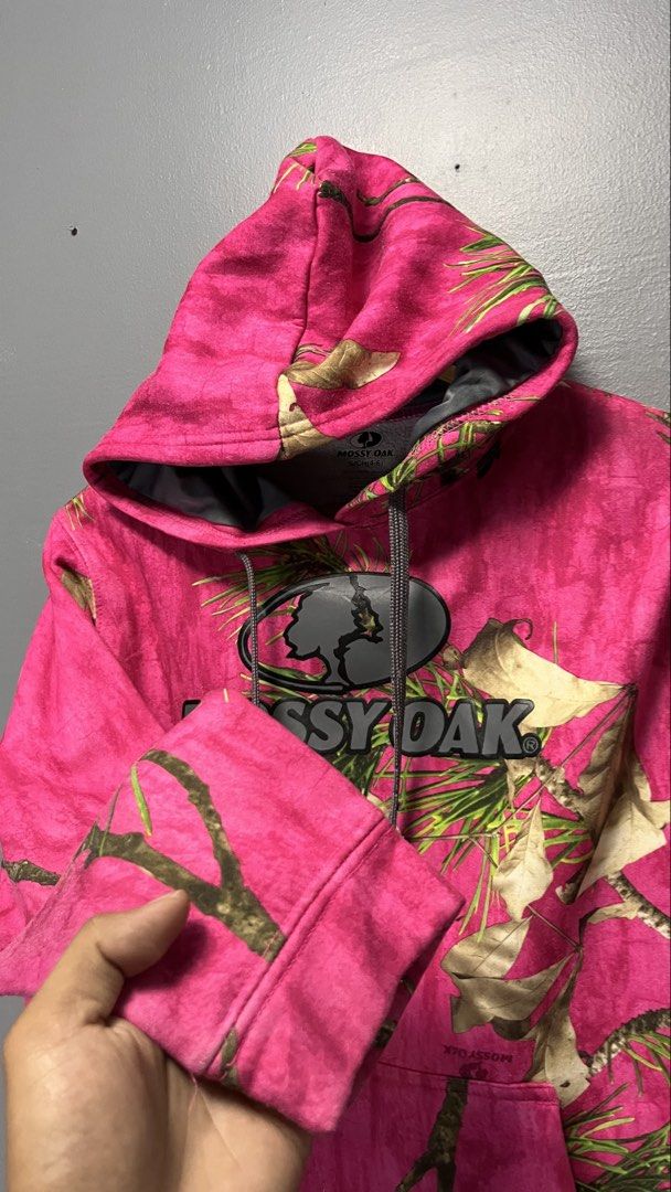 Mossy Oak Pink Camo Hoodie (Category: Hoodies) located in Cabuyao City. Submitted by bulandos (Listing ID 1463436632, Image 3). Description: - Brand: Mossy Oak - Design: Classic camo pattern with a bright pink background - Features: Front pocket, adjustable hood drawstrings - Material: 100% Polyester - Ideal for: Casual wear, outdoor activities.