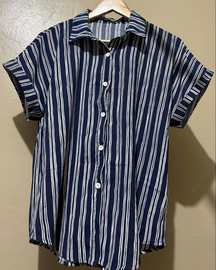 Navy Blue Striped Short Sleeve Button-Up Shirt (Category: Shirts) located in Manila. Submitted by stella_mari27 (Listing ID 1463454325, Image 1). Description: - Classic navy blue shirt with white vertical stripes - Short sleeves with rolled cuff detail - Button-up front - Collared neckline - Versatile for casual or smart-casual outfits - Easy to pair with jeans or shorts.