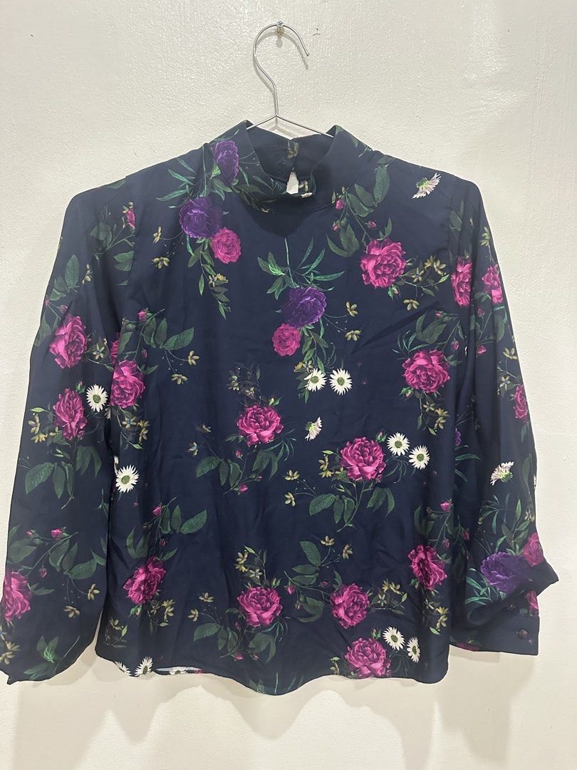 Navy Floral Mock Neck Long Sleeve Blouse Medium (Category: Blouses) located in Manila. Submitted by roseluxuryitems (Listing ID 1463474097, Image 2). Description: - Navy blue long sleeve blouse - Beautiful floral print with pink & purple roses and white daisies - Mock neck design - Button closure at the back - Cuffed sleeves with button detail - Perfect for dressing up or down.