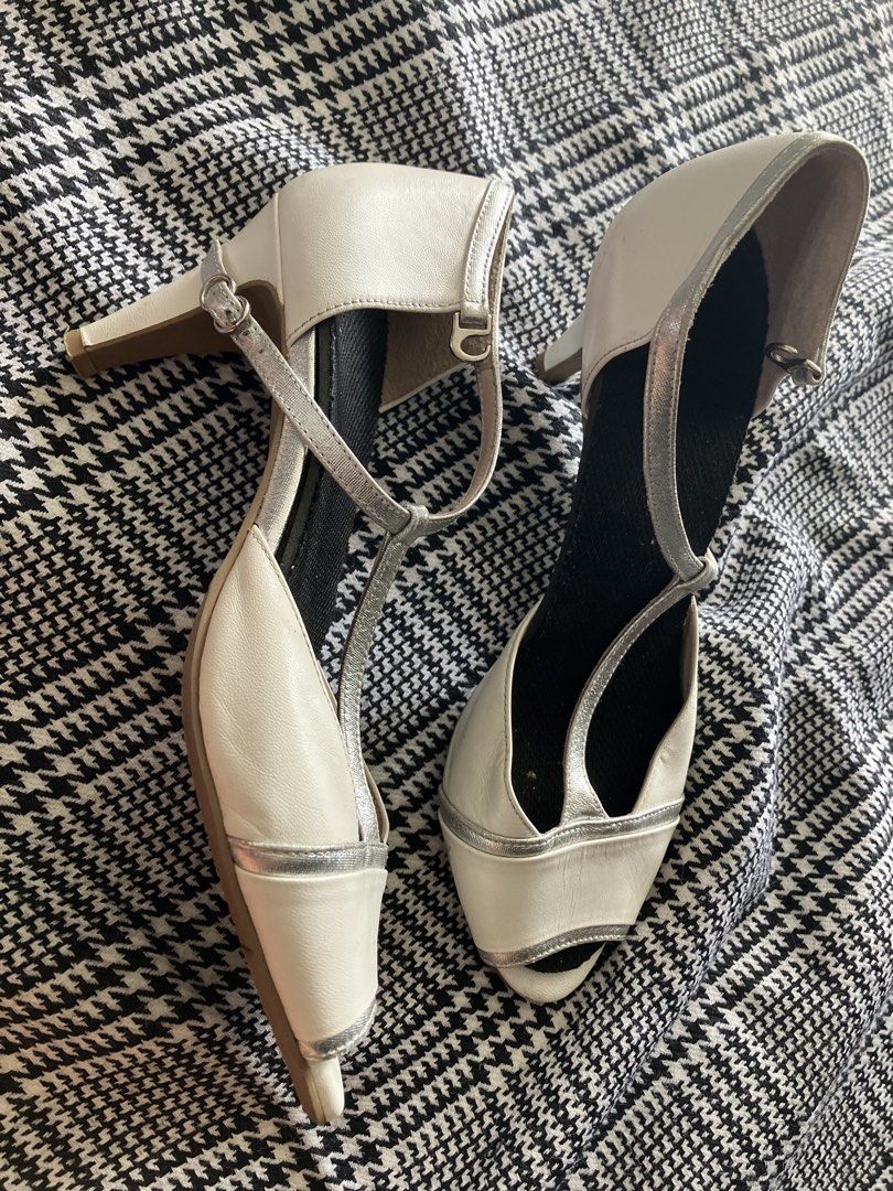 Neorhythm t-strap peep toe heels (Category: Heels) located in Angeles City. Submitted by jnwsurplus (Listing ID 1463365494, Image 1). Description: These appear to be cream and metallic silver T-strap peep-toe heels featuring a delicate buckled ankle strap and subtle contrast piping..