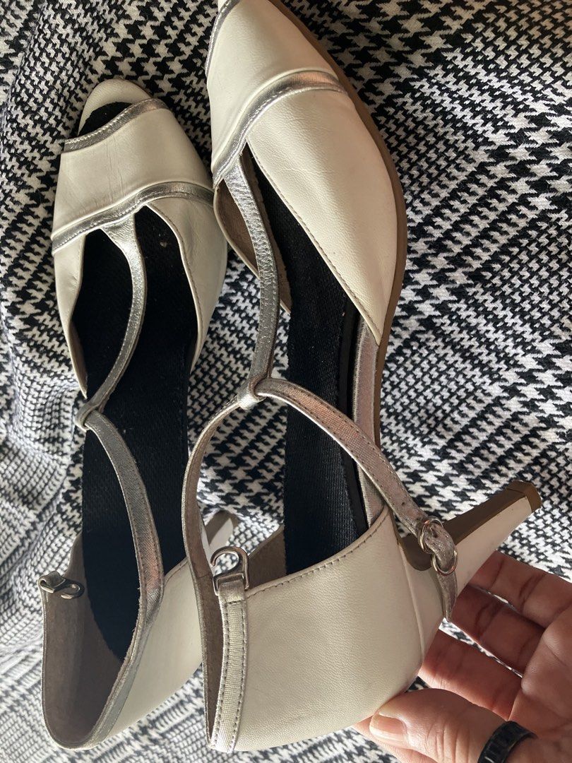 Neorhythm t-strap peep toe heels (Category: Heels) located in Angeles City. Submitted by jnwsurplus (Listing ID 1463365494, Image 3). Description: These appear to be cream and metallic silver T-strap peep-toe heels featuring a delicate buckled ankle strap and subtle contrast piping..