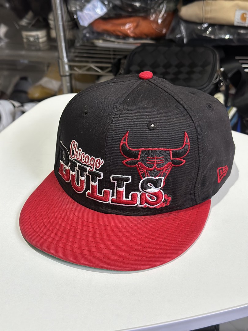 New Era Chicago Bulls NBA Snapback Cap (Category: Caps & Hats) located in Daet. Submitted by thrifthings2018 (Listing ID 1463423977, Image 2). Description: - Authentic Chicago Bulls snapback cap - Classic black and red colorway - Features the iconic Bulls logo and 'Chicago Bulls' text on the front - 'Family' embroidered on the back - New Era branding - Ideal for any basketball and Bulls fan.