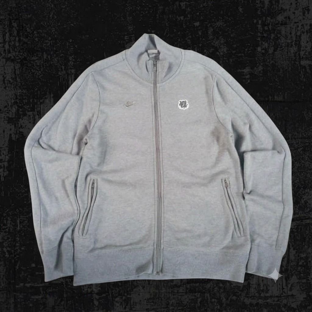 Nike Grey Track Jacket with Crest Logo (Category: Coats, Jackets and Outerwear) located in Pasig City. Submitted by rjkfindsofficial (Listing ID 1463405490, Image 1). Description: - Grey Nike track jacket - Size: L - Dimes L27 x W20 - Features a small embroidered crest logo on the chest - Full zip closure - Includes pockets - Made in China - Ideal for casual wear or sports activities - All zipper working - Complete tags - Minimal stain - Ribbings