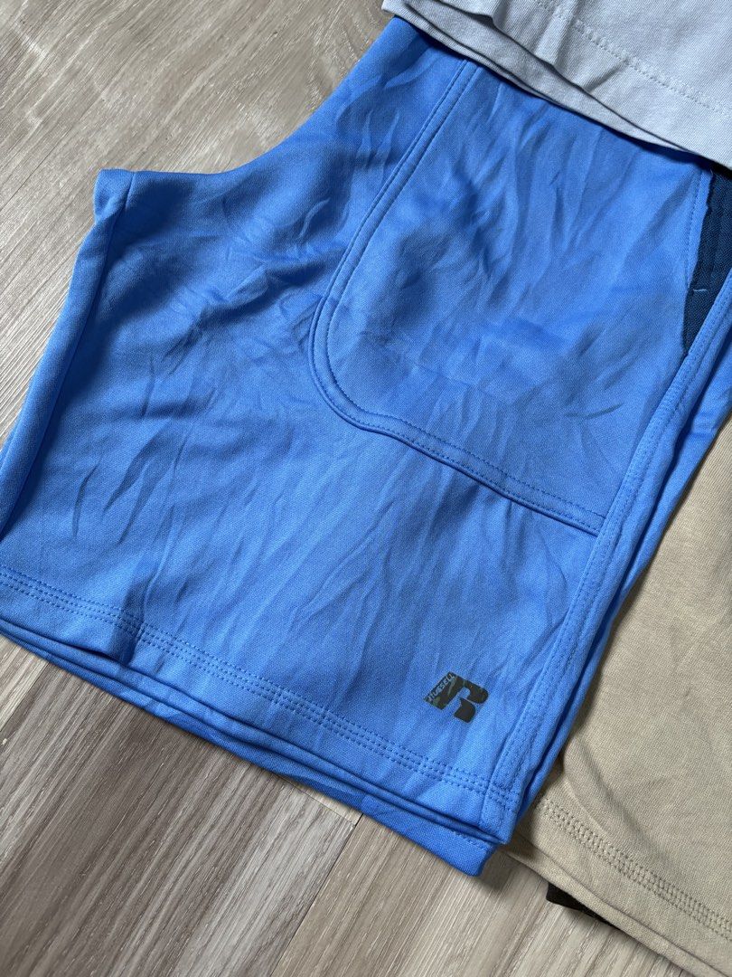 Nike, Puma, Russell Athletic Shorts Bundle (Category: Shorts) located in Rizal. Submitted by thriftdrip.402 (Listing ID 1463495852, Image 3). Description: - Bundle of 5 pairs of men's shorts - Brands include Nike, Puma, and Russell Athletic - Assorted colors: light blue, white with green, tan, black, and grey/blue/dark grey - Features elastic waistbands on all pairs - Ideal for sports activities or casual everyday wear.