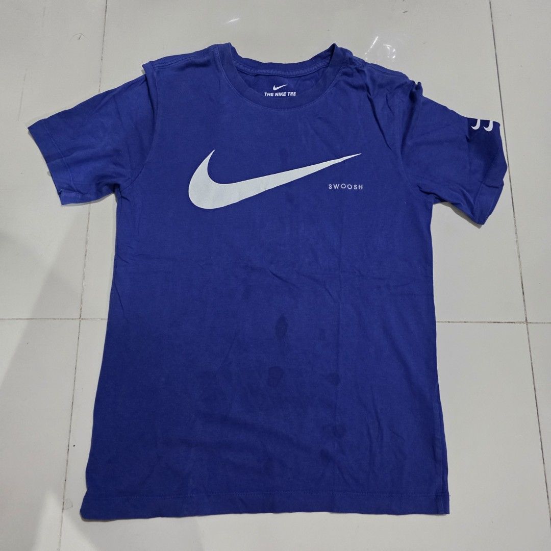 Nike Swoosh T-shirt Blue (Category: Tshirts & Polo Shirts ) located in Quezon City. Submitted by kick_mnl (Listing ID 1463374743, Image 1). Description: - Blue Nike T-Shirt - Large white Swoosh logo with vertical 'SWOOSH' text - 'THE NIKE TEE' printed on the inside collar - Approximate Measurements: 24" chest, 17" shoulder to hem - Ideal for casual everyday wear.