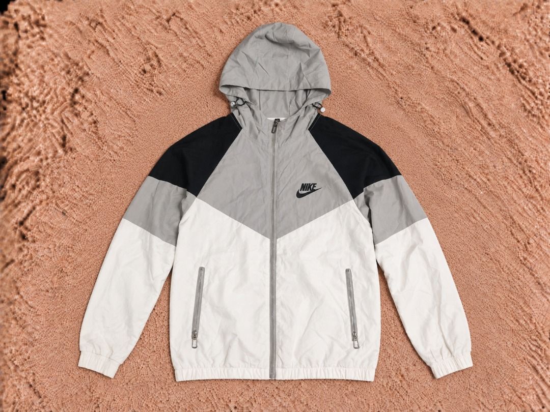 Nike Windrunner Jacket (Category: Coats, Jackets and Outerwear) located in Quezon City. Submitted by drift_and_vibe_thrift (Listing ID 1463512859, Image 1). Description: Classic Nike windrunner jacket. Features the iconic chevron design in grey, black, and white. Lightweight and perfect for layering. Has a full zip closure and a hood. Two zip pockets on the front. Great for casual wear or light outdoor activities..