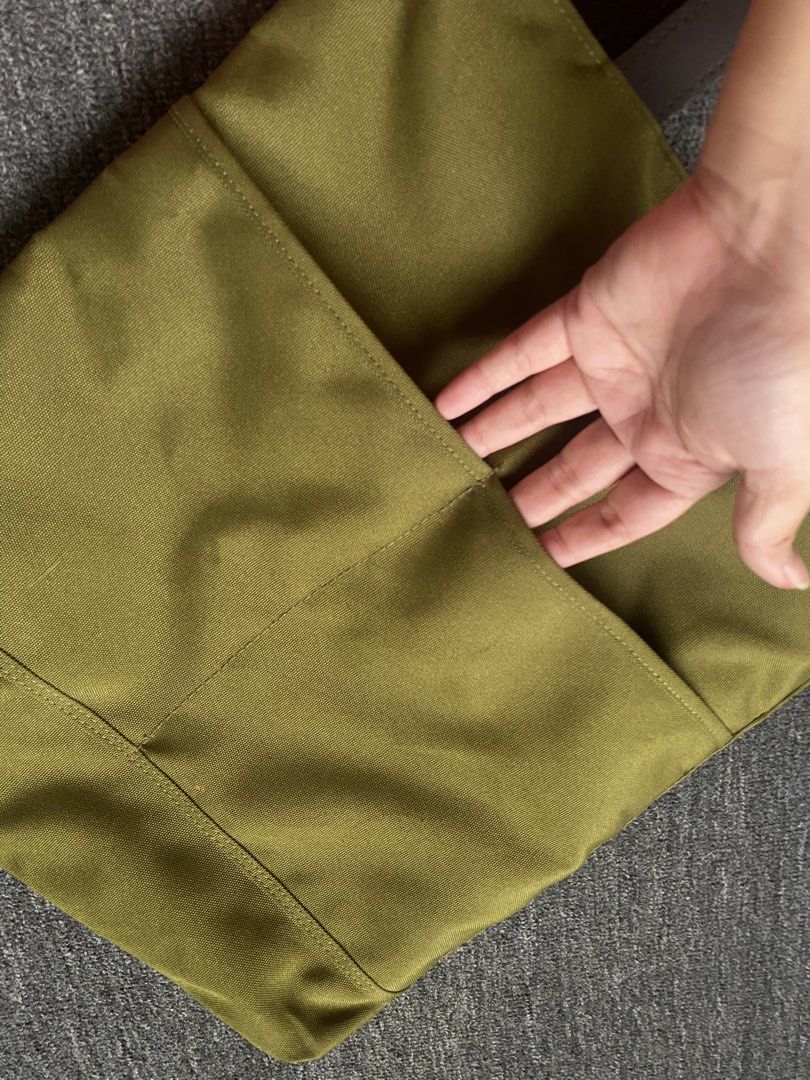Olive Green Tote Bag with Hand-Painted Design (Category: Tote Bags) located in Makati City. Submitted by clutterfree.life (Listing ID 1463389124, Image 3). Description: - Stylish olive green tote bag - Vibrant, colorful leaf illustration on the front - Durable brown leather handles - Secure zippered main compartment - Convenient exterior pockets on the back - Black nylon fabric interior lining - Ideal for everyday use or as a fashion statement On