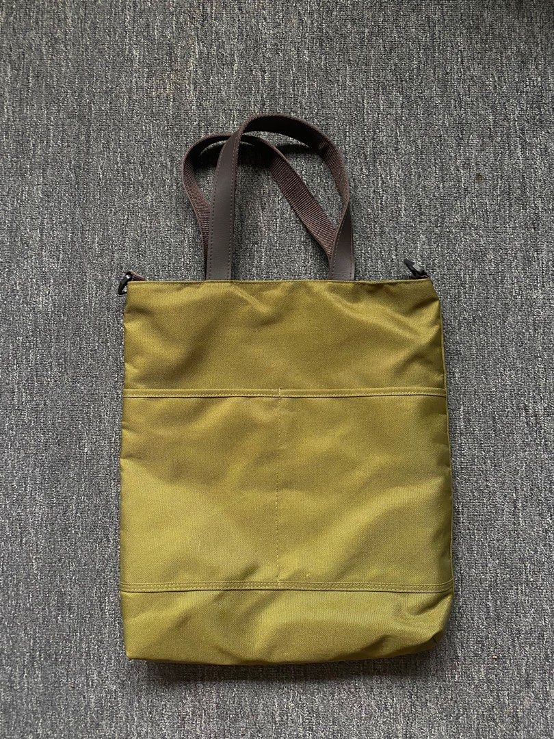 Olive Green Tote Bag with Hand-Painted Design (Category: Tote Bags) located in Makati City. Submitted by clutterfree.life (Listing ID 1463389124, Image 2). Description: - Stylish olive green tote bag - Vibrant, colorful leaf illustration on the front - Durable brown leather handles - Secure zippered main compartment - Convenient exterior pockets on the back - Black nylon fabric interior lining - Ideal for everyday use or as a fashion statement On