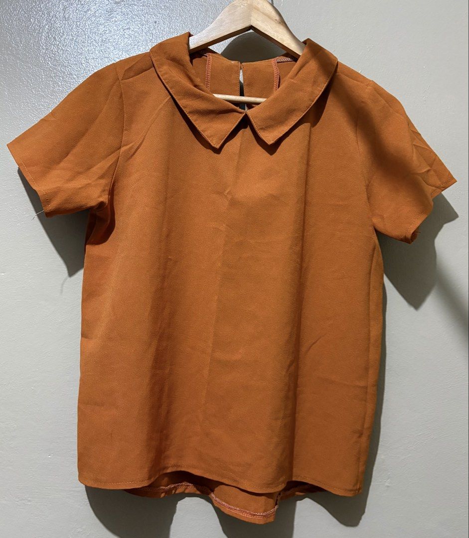 Orange Peter Pan Collar Short Sleeve Top (Category: Blouses) located in Manila. Submitted by stella_mari27 (Listing ID 1463444916, Image 1). Description: - Adorable orange top - Features a classic Peter Pan collar - Short sleeves for comfort - Stylish cutout detail at the back with button closure - Fabric has a lovely texture - Versatile piece: pairs well with jeans or skirts - Ideal for casual outings.