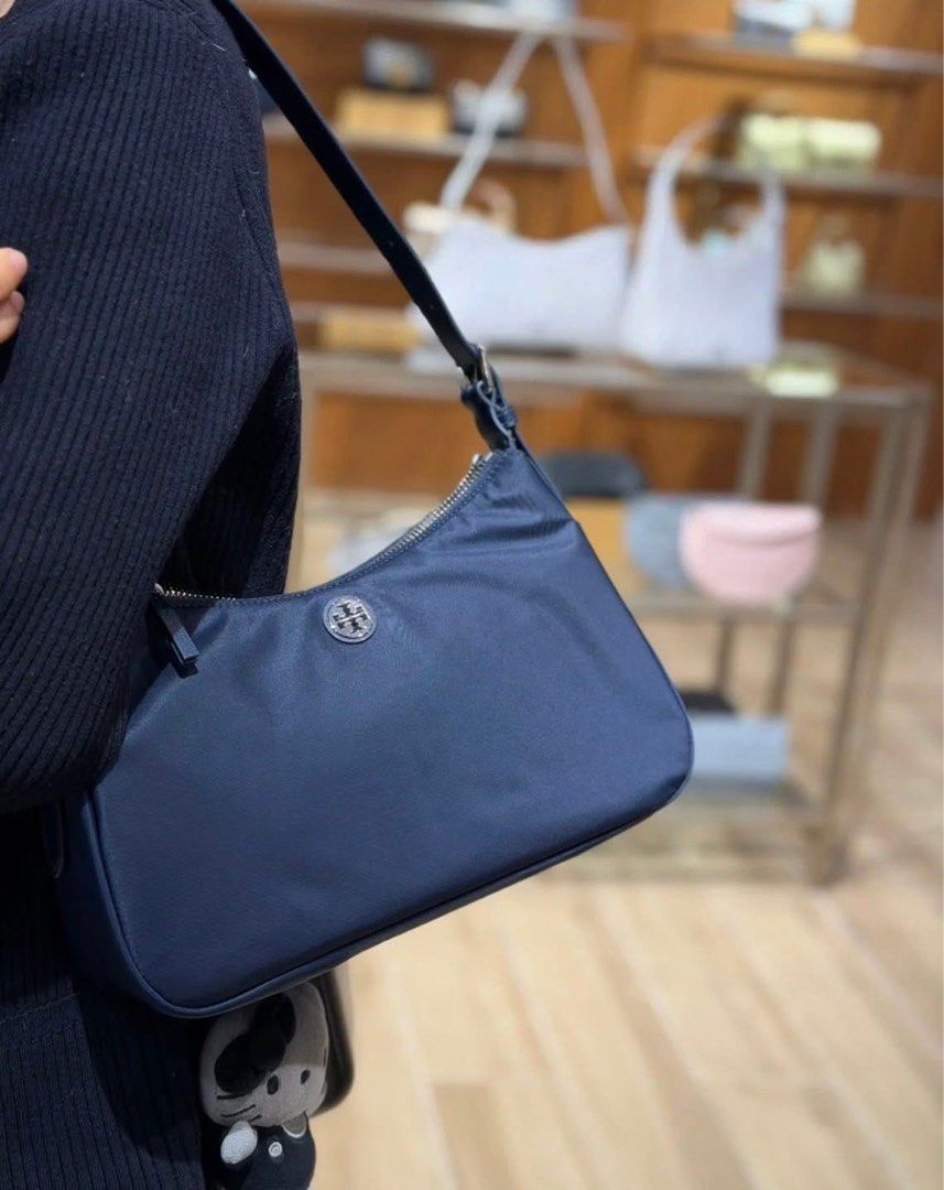 💯ORIGINAL TORY BURCH SMALL NYLON TOP ZIP SHOULDER BAG (Category: Shoulder Bags) located in Quezon City. Submitted by ashongsstore (Listing ID 1463354777, Image 2). Description: ✨T0RY BURCH COLLECTION✨ 🇵🇭AVAILABLE🇵🇭 SHW NAVY NYLON SMALL ZIP SHOULDER BAG From the TB Nylon collection, this blue bag features one main compartment with a silver zip closure, one internal zip pocket, and an adjustable strap. Made of nylon, the design showcases a sil