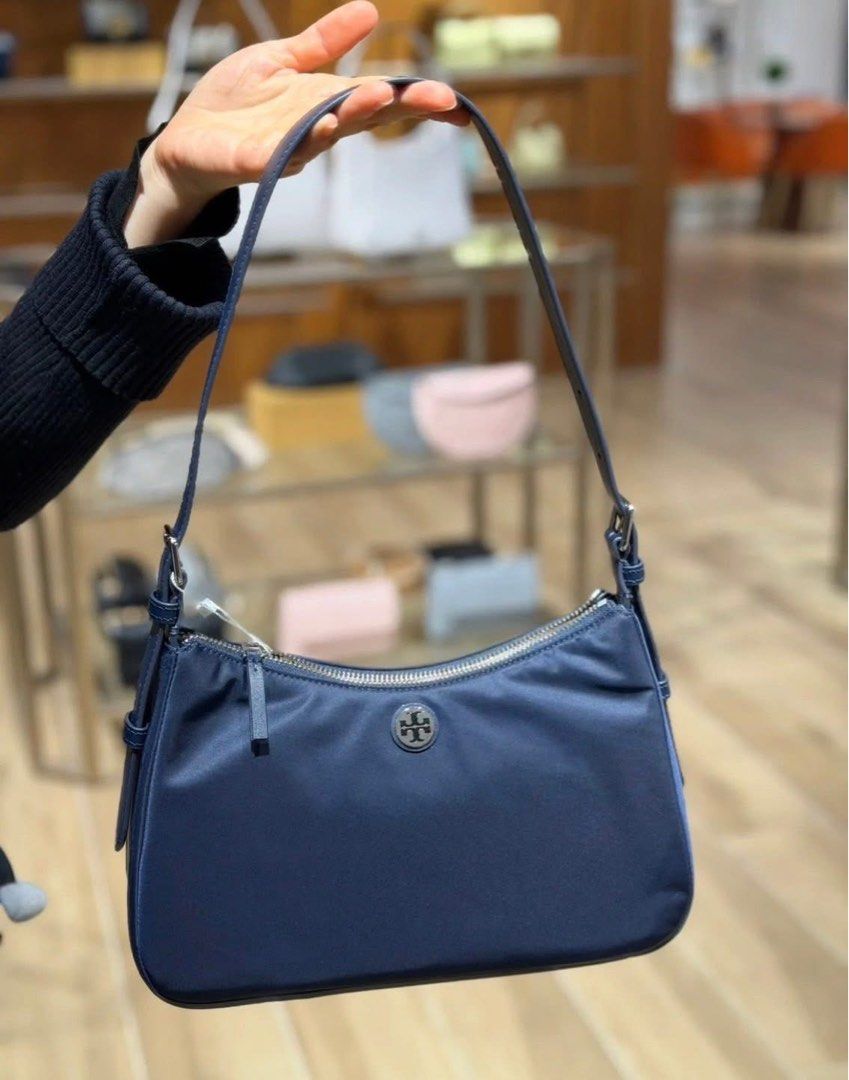 💯ORIGINAL TORY BURCH SMALL NYLON TOP ZIP SHOULDER BAG (Category: Shoulder Bags) located in Quezon City. Submitted by ashongsstore (Listing ID 1463354777, Image 1). Description: ✨T0RY BURCH COLLECTION✨ 🇵🇭AVAILABLE🇵🇭 SHW NAVY NYLON SMALL ZIP SHOULDER BAG From the TB Nylon collection, this blue bag features one main compartment with a silver zip closure, one internal zip pocket, and an adjustable strap. Made of nylon, the design showcases a sil