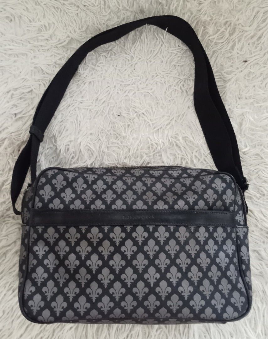 Patrick Cox Black & Grey Fleur-de-lis Crossbody Bag (Category: Cross-body Bags) located in Caloocan City. Submitted by noy5o1a (Listing ID 1463364774, Image 1). Description: - Stylish black and grey crossbody bag - Features a repeating fleur-de-lis pattern - Multiple zippered compartments for easy organization - Adjustable strap for comfortable wear - Ideal for everyday use or travel.