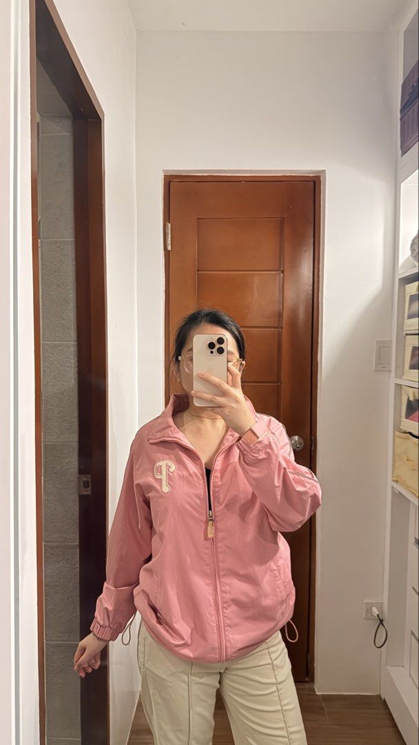 Philadelphia Phillies pink windbreaker jacket (Category: Coats, Jackets and Outerwear) located in Santa Rosa. Submitted by stealbydiva (Listing ID 1463340049, Image 3). Description: - Cute pink track jacket - Zipper closure - Small 'P' logo on chest - Drawstrings at the hem for adjustable fit - Versatile for casual wear or light workouts - Can be worn zipped up or open.