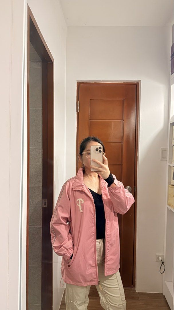 Philadelphia Phillies pink windbreaker jacket (Category: Coats, Jackets and Outerwear) located in Santa Rosa. Submitted by stealbydiva (Listing ID 1463340049, Image 2). Description: - Cute pink track jacket - Zipper closure - Small 'P' logo on chest - Drawstrings at the hem for adjustable fit - Versatile for casual wear or light workouts - Can be worn zipped up or open.