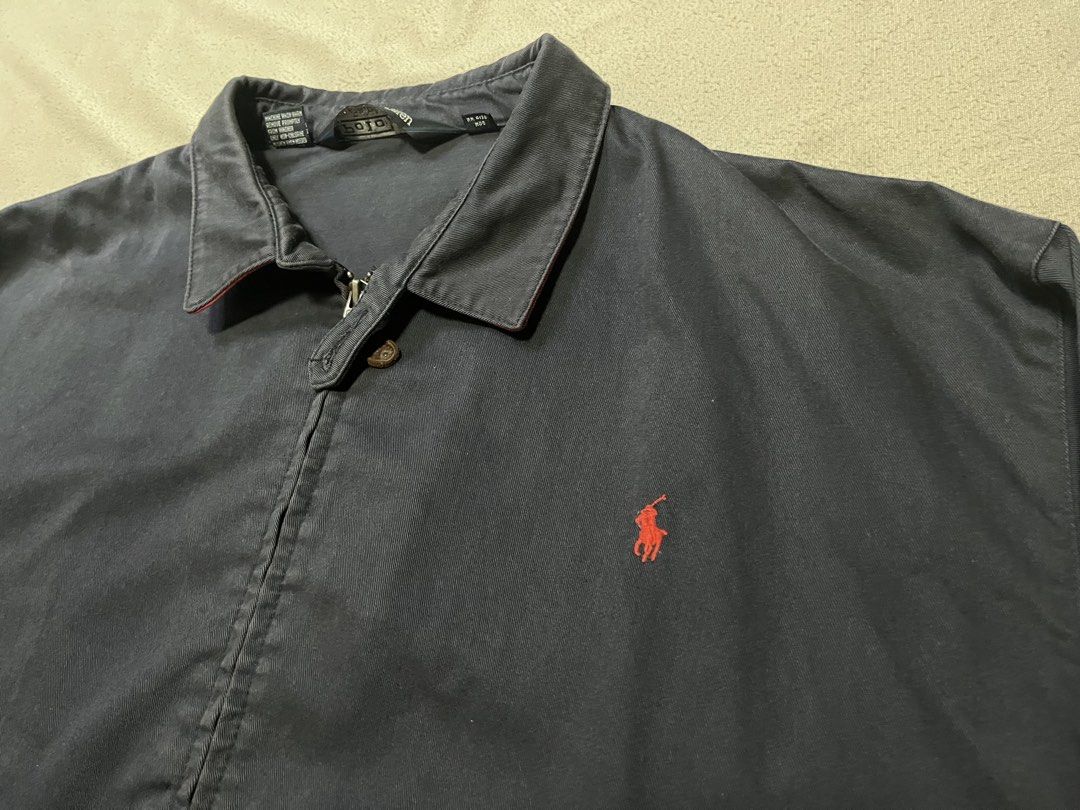 Polo Ralph Lauren Navy Harrington Jacket (Category: Coats, Jackets and Outerwear) located in Quezon City. Submitted by gvsfinds_ (Listing ID 1463492853, Image 2). Description: Authentic Ralph Lauren navy blue harrington jacket with red lining under the collar. Size: XL Dimensions: - Length: 28 - Width: 27 - Sleeve: 20 - Shoulder: 24 Issue: Patch on left sleeve. Price is negotiable..