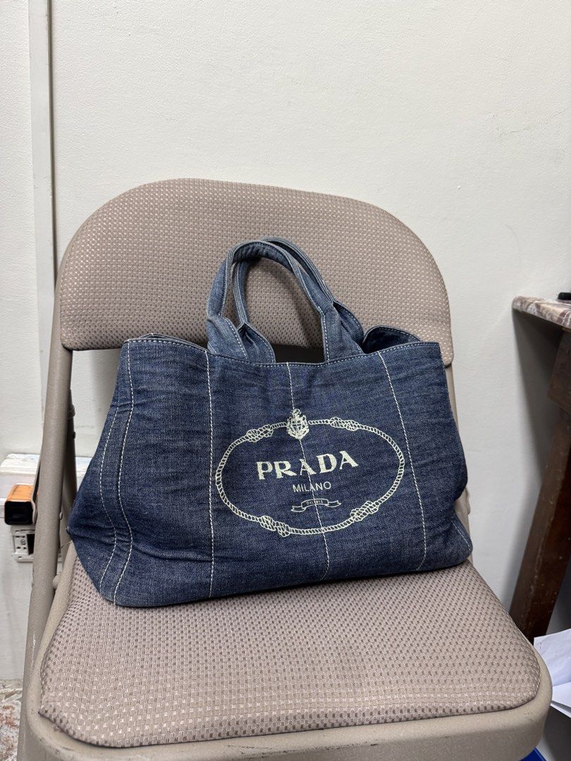 Prada Denim Tote Bag (Category: Luxury Bags & Wallets) located in Cabanatuan. Submitted by dgbordador (Listing ID 1463382599, Image 1). Description: - Classic Prada tote bag in stylish denim. - Features the iconic Prada logo prominently on the front. - Elegant gold hardware, including zipper and base studs. - Generously spacious interior, ideal for everyday essentials. - A timeless and chic accessory from Prada Milano..