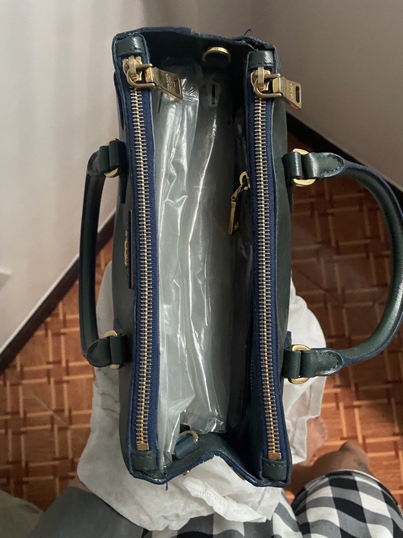 Prada Saffiano Leather Top Handle Bag Dark Green (Category: Luxury Bags & Wallets) located in Manila. Submitted by ch1lleroli82692 (Listing ID 1463429398, Image 3). Description: - Authentic dark green Prada bag - Made from durable Saffiano leather - Elegant gold hardware details - Secure top zip closure - Interior zip pocket for essentials - Sturdy and comfortable handles - Comes with original dust bag - Ideal for daily use and versatile styling.