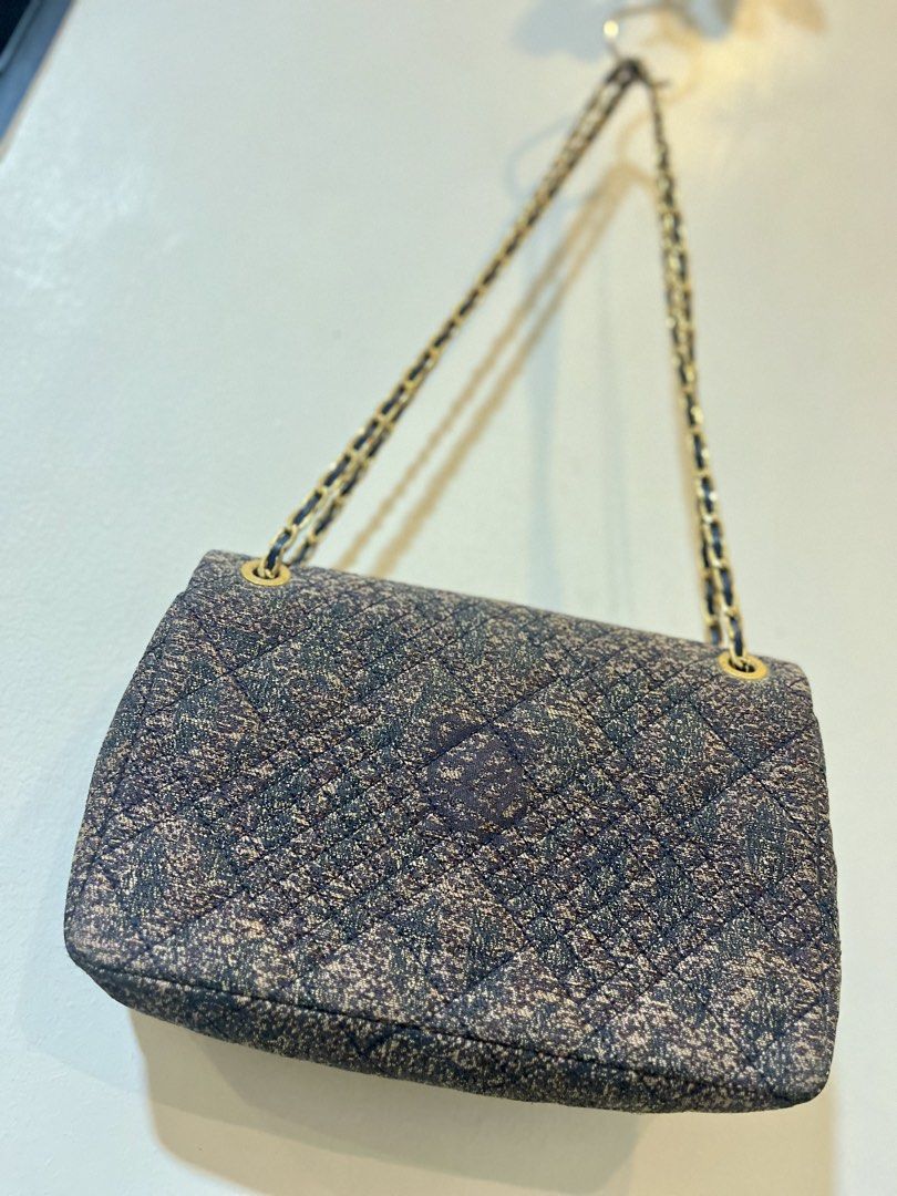 Quilted Chain Shoulder Bag with Gold Clasp (Category: Luxury Bags & Wallets) located in Bacolod City. Submitted by vintage_vogue6100 (Listing ID 1463380400, Image 2). Description: - Stylish quilted shoulder bag - Textured fabric exterior - Elegant gold chain strap - Prominent gold logo clasp - Multiple interior compartments - Includes a zippered pocket - Lined with a repeating pattern - Ideal for carrying your daily essentials.