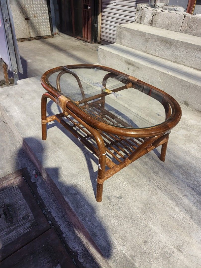 Rattan Coffee Table with Glass Top (Category: Tables & Sets) located in Valenzuela. Submitted by kendra071914 (Listing ID 1463466777, Image 3). Description: - Oval rattan coffee table - Clear glass top - Lower shelf for extra storage - Dimensions: H-43cm, L-84cm, W-47cm - Minor signs of wear on rattan, adding character - Ideal for living room or patio use.