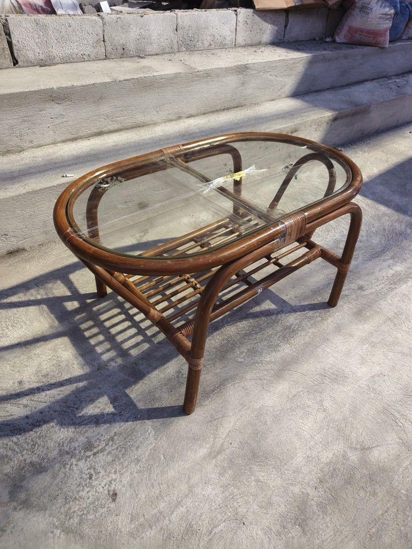 Rattan Coffee Table with Glass Top (Category: Tables & Sets) located in Valenzuela. Submitted by kendra071914 (Listing ID 1463466777, Image 2). Description: - Oval rattan coffee table - Clear glass top - Lower shelf for extra storage - Dimensions: H-43cm, L-84cm, W-47cm - Minor signs of wear on rattan, adding character - Ideal for living room or patio use.
