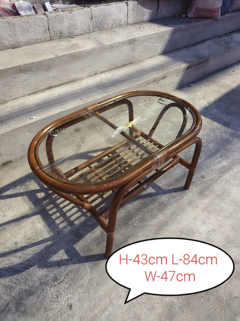 Rattan Coffee Table with Glass Top (Category: Tables & Sets) located in Valenzuela. Submitted by kendra071914 (Listing ID 1463466777, Image 1). Description: - Oval rattan coffee table - Clear glass top - Lower shelf for extra storage - Dimensions: H-43cm, L-84cm, W-47cm - Minor signs of wear on rattan, adding character - Ideal for living room or patio use.