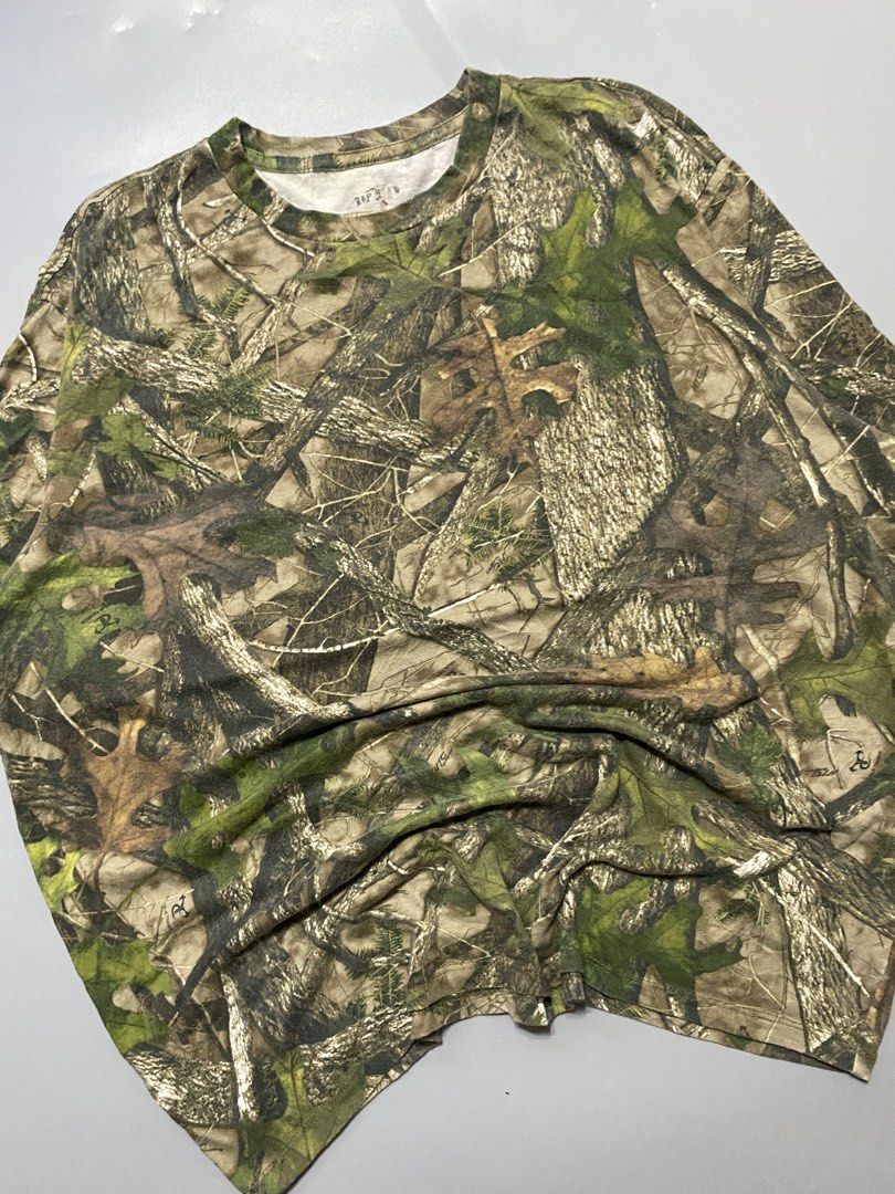 Real Tree Camo T-Shirt - Size L (Category: Tshirts & Polo Shirts ) located in Silang. Submitted by kenneth_ukays (Listing ID 1463342882, Image 2). Description: - Authentic Real Tree camouflage pattern - Comfortable short-sleeve, crew neck design - Ideal for outdoor adventures or casual wear - Durable and breathable material - Tag details visible for reference.