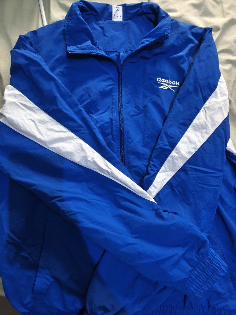 Reebok Track Jacket Windbreaker Blue White (Category: Coats, Jackets and Outerwear) located in Pasig City. Submitted by y2j2oratod (Listing ID 1463451786, Image 2). Description: - Classic Reebok windbreaker jacket - Bright blue with white stripe details on sleeves - Full zip front with collar - Elasticated cuffs and hem - Ideal for casual wear or sports - Lightweight and packable for on-the-go convenience.