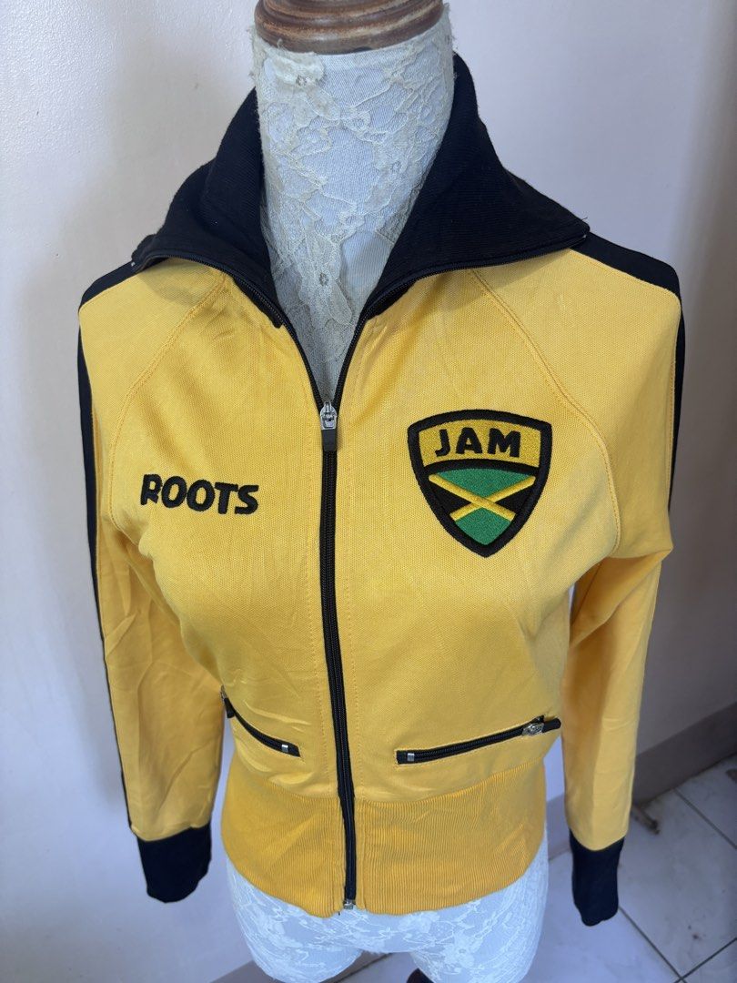 Roots Jamaica Track Jacket Yellow Black (Category: Coats, Jackets and Outerwear) located in Manila. Submitted by galitsabarat (Listing ID 1463410232, Image 2). Description: - Yellow track jacket with black accents - 'ROOTS' on front left chest - 'JAM' crest detail - Large 'JAMAICA' lettering on the back - Full zip front closure - Zippered hand pockets - Ribbed cuffs and hem for a snug fit - Ideal for casual outings or displaying national pride.