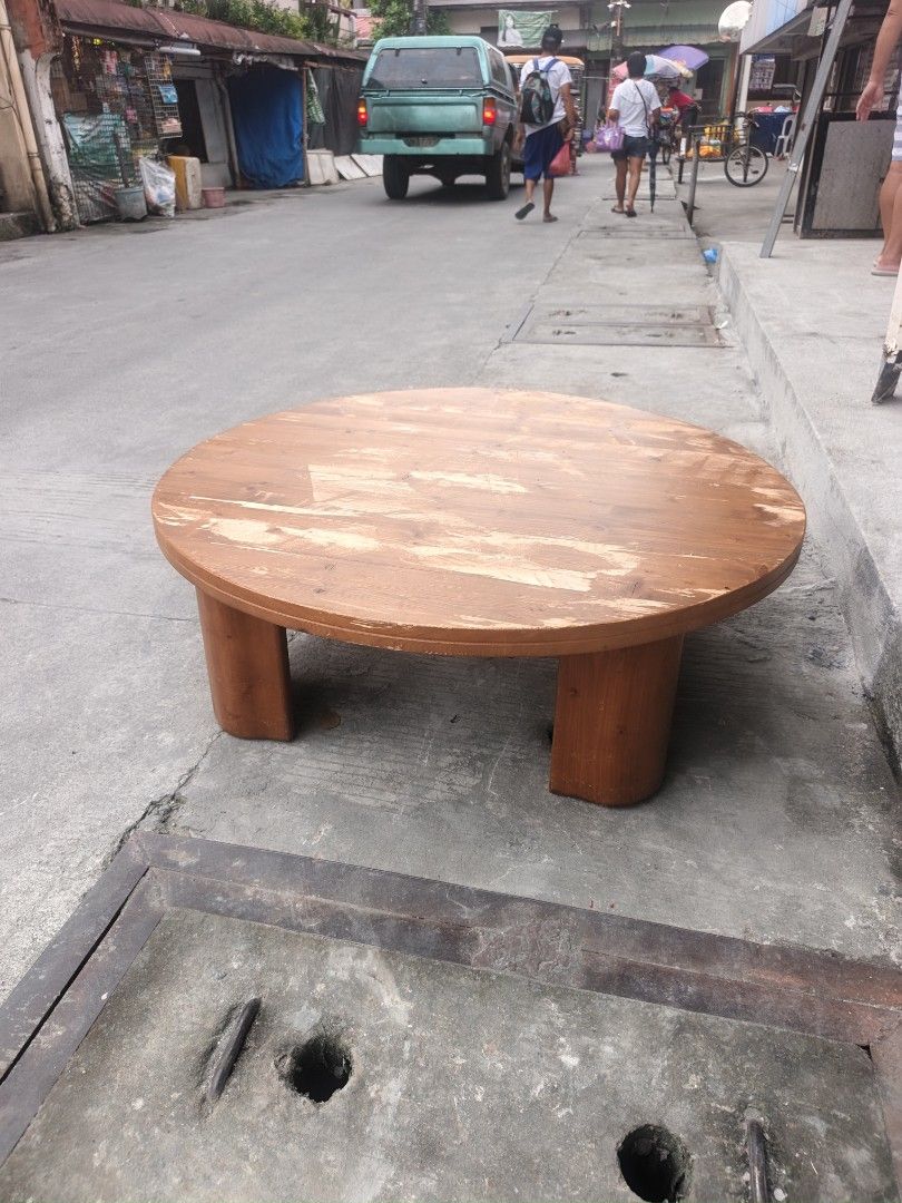 Round Wooden Coffee Table (Category: Tables & Sets) located in Valenzuela. Submitted by kendra071914 (Listing ID 1463463995, Image 1). Description: - Round wooden coffee table - Made of solid wood - Surface wear and tear visible (as pictured) - Sturdy legs - Ideal for living rooms or lounge areas - Ready for a new home.