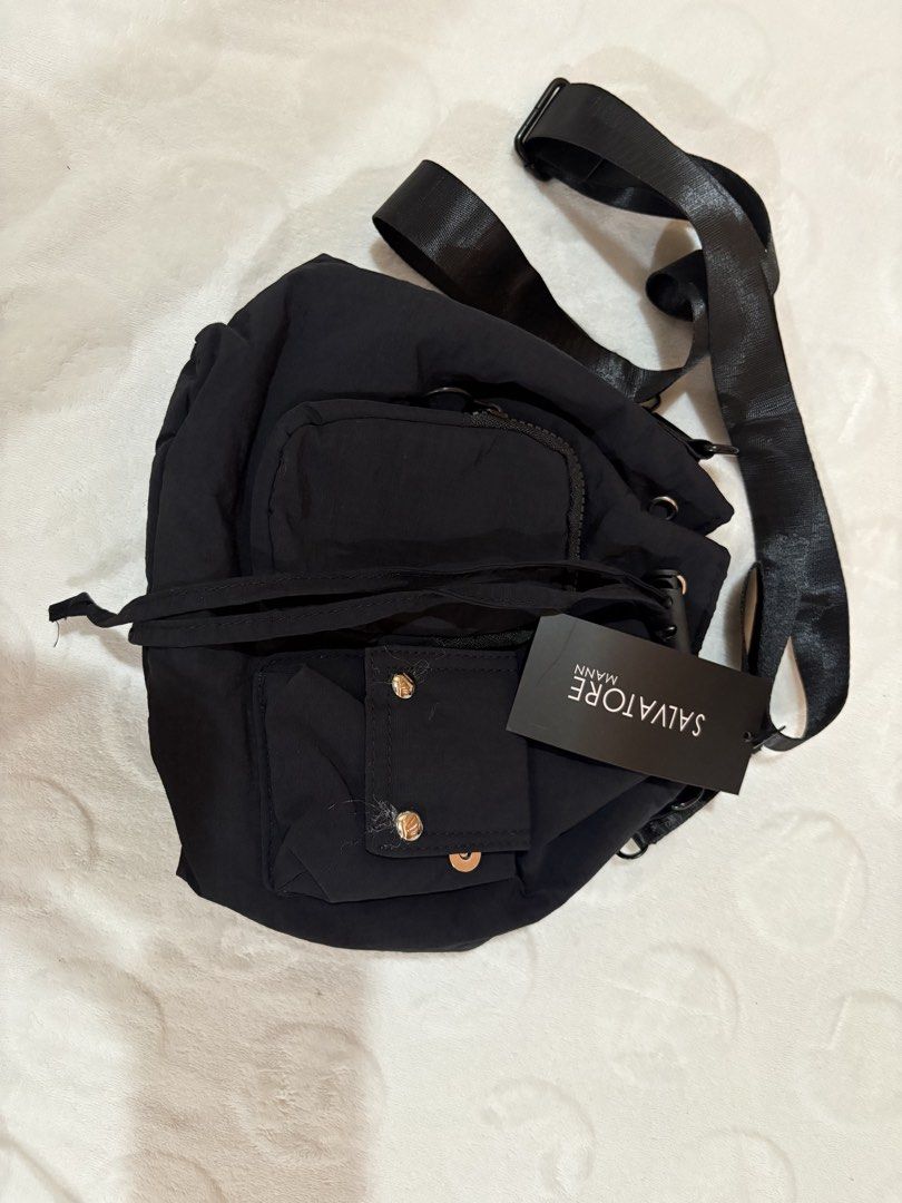 Salvatore Mann Black Nylon Drawstring Backpack (Category: Backpacks) located in Manila. Submitted by dig76 (Listing ID 1463357597, Image 1). Description: - Salvatore Mann black drawstring backpack - Main compartment - Front zip pocket - Two smaller front pockets with button closures - Adjustable straps - Ideal for everyday use or travel - Clean inside and out.