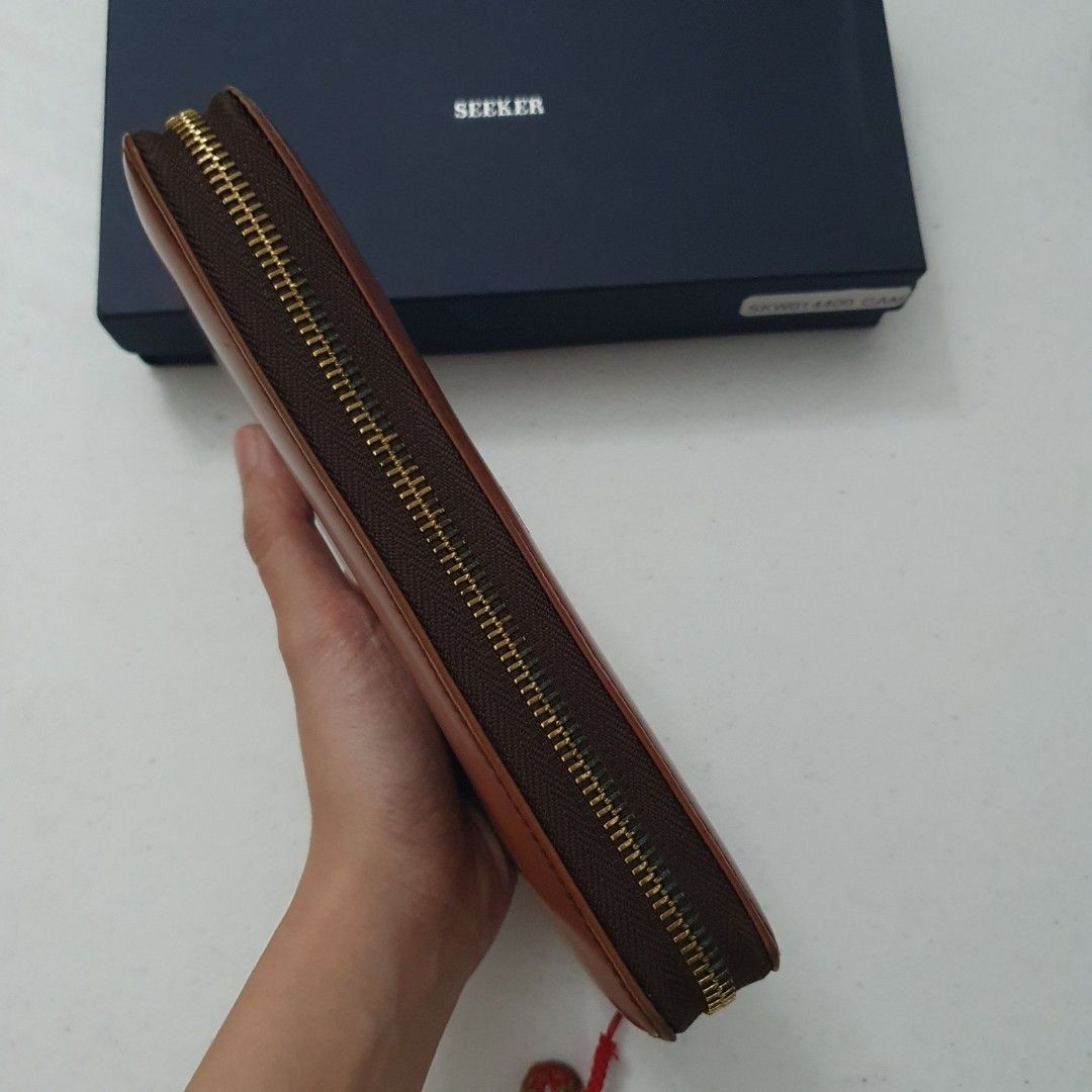 Seeker Leather Long Wallet Brown (Category: Wallets & Card holders) located in Paranaque City. Submitted by cobien (Listing ID 1463450978, Image 3). Description: - Brand: Seeker - Material: Brown Leather - Closure: Zipper - Features: Ample card slots and compartments for organization - Includes: Original box and tag - Ideal for: Keeping your essentials neatly organized - flaw: no puller and minimal rubs on the edges.
