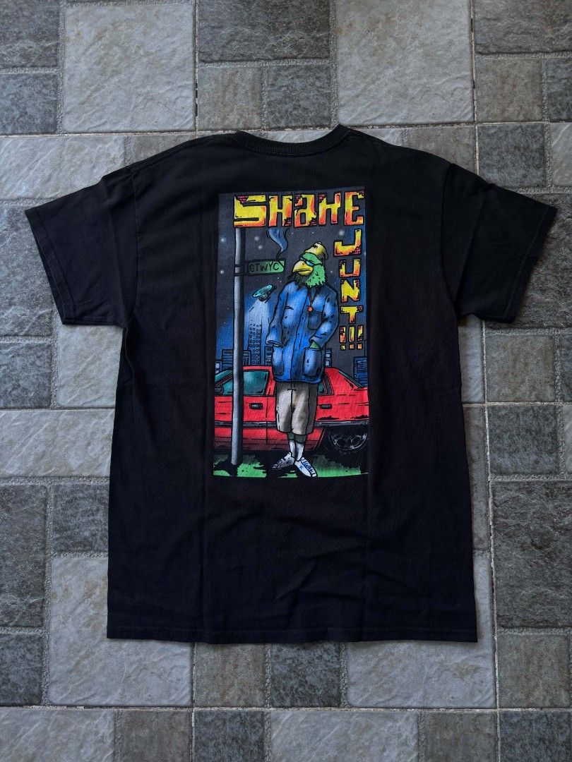Shake Junt Graphic T-Shirt (Category: Tshirts & Polo Shirts ) located in Iriga City. Submitted by thrifttobicol29 (Listing ID 1463450248, Image 2). Description: - Black t-shirt - Features a cool graphic of a bird character in a city scene on the back - Small logo on the front chest - Perfect for casual everyday wear - Shake junt Medium W 19" L 28" Excellent condition .
