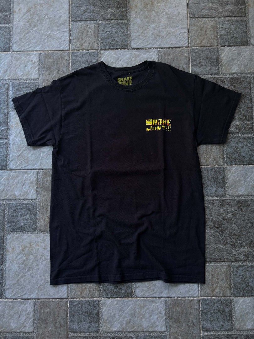 Shake Junt Graphic T-Shirt (Category: Tshirts & Polo Shirts ) located in Iriga City. Submitted by thrifttobicol29 (Listing ID 1463450248, Image 1). Description: - Black t-shirt - Features a cool graphic of a bird character in a city scene on the back - Small logo on the front chest - Perfect for casual everyday wear - Shake junt Medium W 19" L 28" Excellent condition .
