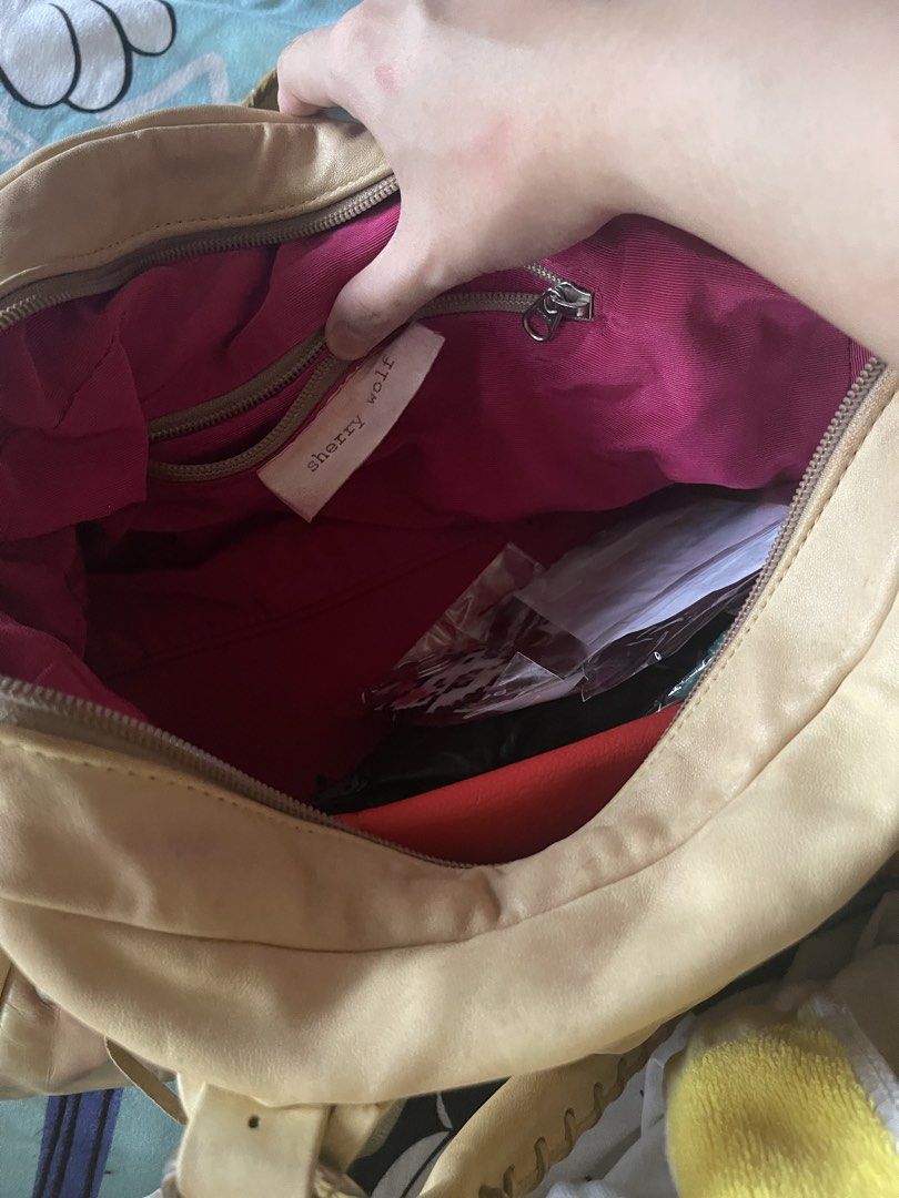 Sherry Wolf Bag (Category: Luxury Bags & Wallets) located in Quezon City. Submitted by rish40 (Listing ID 1463403278, Image 3). Description: - keychains/charms and items inside bag not included - Tan leather shoulder bag by Sherry Wolf - Genuine leather - Secure zip closure - Vibrant pink interior lining - Ample space for your essentials - Comes with a cute crocheted cherry charm - Ideal for everyday use.